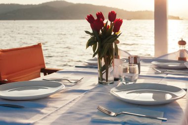 plaj restoranında çiçeklerle masa seti