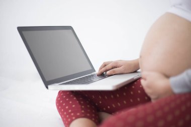 Hamile kadın ile ekranda boş boşaltmak dizüstü dizüstü bilgisayar kullanarak.