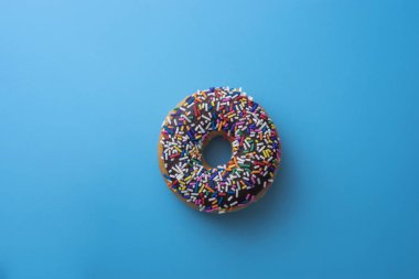 Çörek ile sprinkles pastel arka plan üzerinde