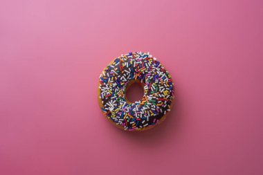 Çörek ile sprinkles pastel arka plan üzerinde