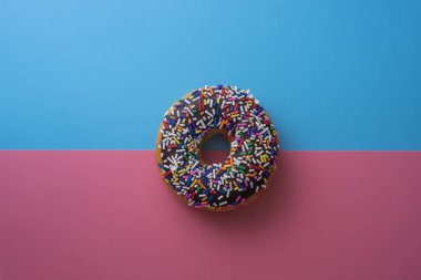 Çörek ile sprinkles pastel arka plan üzerinde