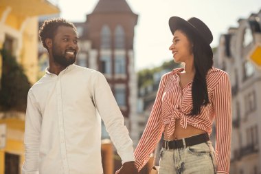 Yürürken birbirlerine gülümseyen genç yetişkinlerin romantik çift