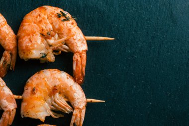 Üzerinde karides şişleri olan siyah kayrak yüzeyi. Sağ taraftaki alanı kopyalama