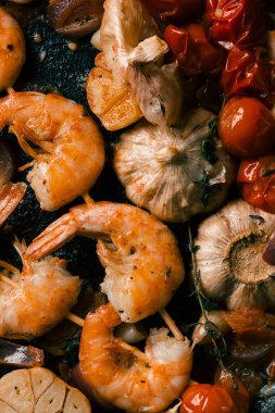 Haşlanmış kiraz domates ve sarımsak karanfil ile kızarmış karides şiş üst görünümü