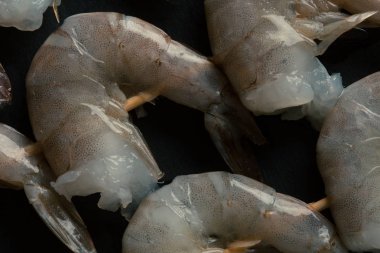 Ahşap şişler üzerinde pişmemiş taze başsız kaplan karides yakın