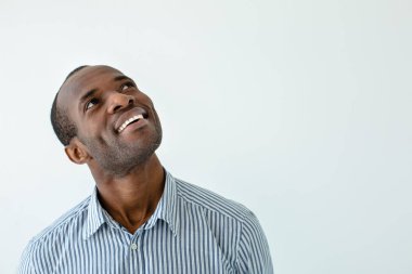 Ne var orada. Neşeli afro amerikan adam yukarı bakarken gülümseyen