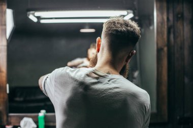 Profesyonel deneyimli berber ayakta ve berber dükkanında iken müşteri ile çalışan