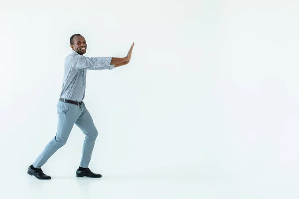 Pohyb Optimistický Afroamerický Muž Který Tlačí Blok Proti Bílému Pozadí — Stock fotografie