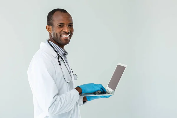 Berührung Freudiger Afroamerikanischer Arzt Der Seinen Laptop Benutzt Und Gleichzeitig — Stockfoto