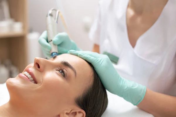 Gezicht Van Gelukkig Lachende Vrouw Hand Van Schoonheidsspecialiste Doen Dermabrasie — Stockfoto