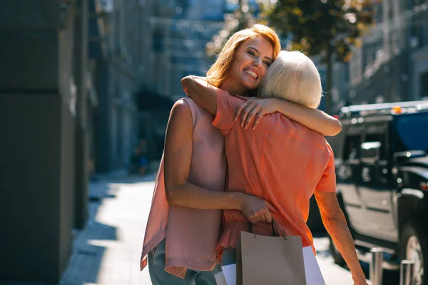 Mulher Alegre Com Sacos Papel Abraçando Sua Mãe Rua Sorrindo — Fotografia de Stock