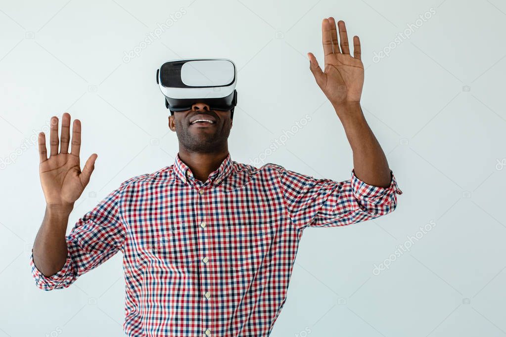 Touchable technologies. Waist up of cheerful smiling afro american man testing VR gadget while standing against white background