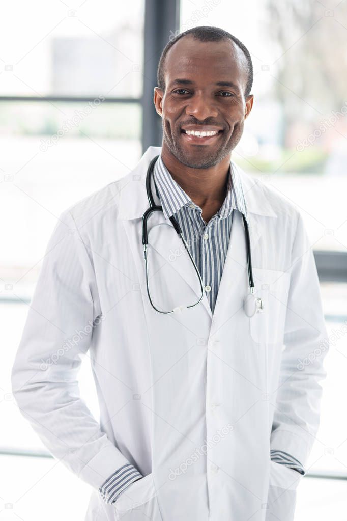 Waiting for patient. Delighted young man expressing positivity while staring at you