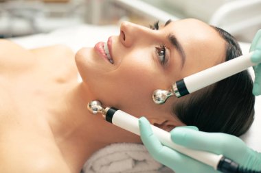 Mikroakım tedavisi görürken gülümseyen güzel genç kadının yüzü