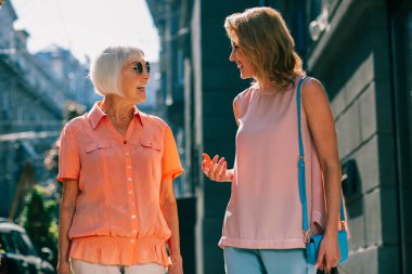 Güneşli havalarda iki gülümseyen kadın Olumlu dostu konuşma