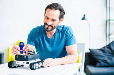 Onun mühendislik hobi tadını çıkarırken modern bir robot kullanarak Pozitif yetişkin adam