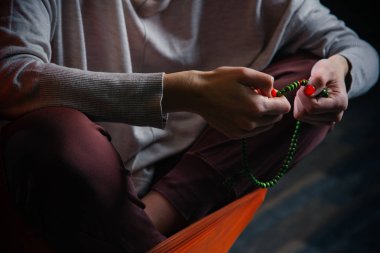 Meditasyon yaparken boncuk güzel yeşil dize kullanarak rahat giysiler içinde kadının yakın