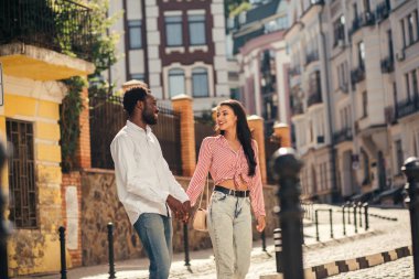 Mutlu genç adam onunla sokakta yürürken kız arkadaşı gülümseyen