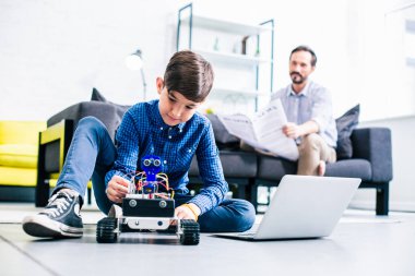 Akıllı memnun çocuk mühendislik sınıfları için hazırlanırken robotunu test