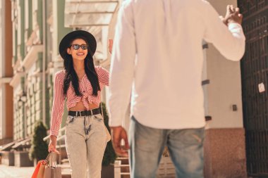 Alışveriş poşetleri ile pozitif kadın sokakta arkadaşı tebrik