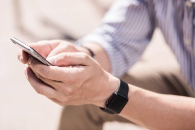 Gadget kullanılıyor. Bir akıllı telefonun açık havada kullanan bir adamın elinde yakınlaş