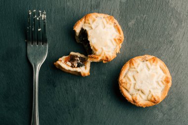 Yaban mersini dolgulu geleneksel kıyma turtalarının en iyi görünümü. Kırıntıları ile çatal yakınında yatan kırık parça