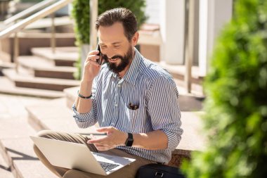 Seni duyduğuma sevindim. Onun laptop kullanırken telefonda konuşurken Neşeli yetişkin adam