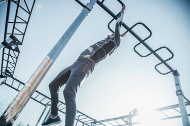 Kendine güvenen güçlü sporcu spor sahasında tek başına olmak ve dikkatle çene yukarı bar tırmanma ise onun eğitim