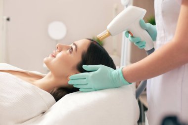 Sakin genç bayan yan görünümü yalan ve yara kaldırma lazer prosedürü geçiyor