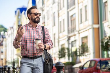 Şehirde bir gün. Kahve içerken sokakta yürüyen pozitif sakallı adam