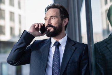 Güzel konuşma. Kenara bakarken telefonda konuşan iyimser bir işadamının portresi