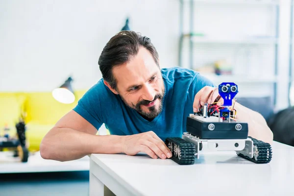 Overjoyed Curioso Adulto Homem Construindo Dispositivo Robótico Enquanto Desfruta Engenharia — Fotografia de Stock
