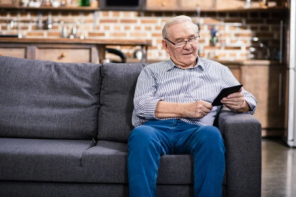 Tecnologias Modernas Homem Idoso Alegre Sentado Sofá Enquanto Book — Fotografia de Stock