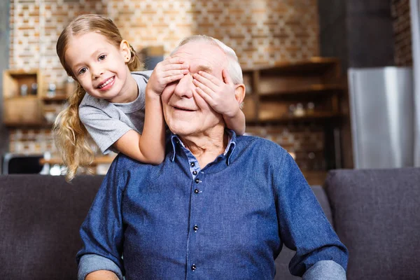 玩得开心点快乐微笑的小女孩闭上眼睛 她的祖父 而玩游戏 — 图库照片