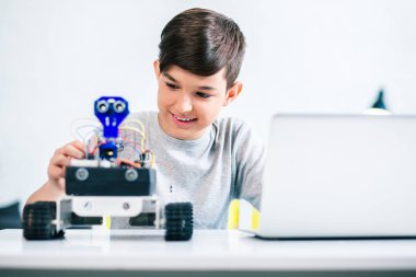 Evde mühendislik dersleri için hazırlanırken robot kadar çalışıyor neşeli gülümseyen çocuk