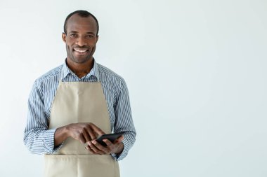 Para önemlidir. Neşeli afro amerikan kafe sahibi beyaz arka plan karşı dururken gülümseyen