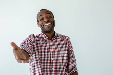 Sana tanıdığıma sevindim. Neşeli gülümseyen afro amerikan adam önde elini tutarken gülümseyen