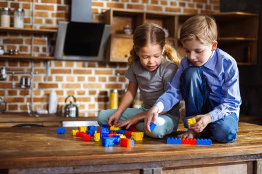 Okul öncesi eğitim. Yapı taşları ile oynarken evde dinlenen pozitif küçük kardeşler