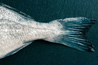 Ham bir gilthead pürüzsüz temiz kuyruk ile siyah bir arduvaz üst görünümü