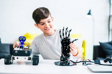 Neşeli hoş çocuk modern mühendislik okurken onun robot cihazları test