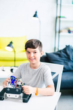 Evde hobisini tadını çıkarırken robotik cihaz kullanarak akıllı pozitif bir öğrencinin bel