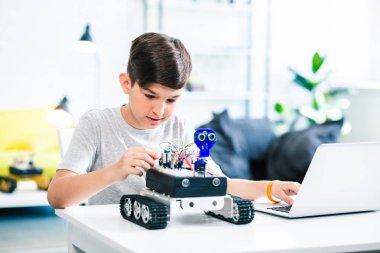 Robot teknolojileri ile deney yaparken onun laptop kullanarak Nice küçük çocuk