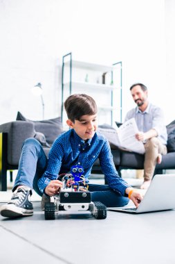 Robotik cihazı test ederken dizüstü bilgisayarını kullanan dahice küçük çocuk