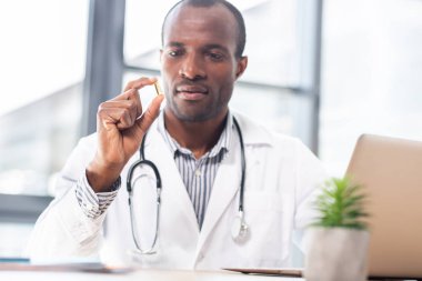 Sadece bak. Ciddi uygulayıcı steril üniforma giyen ve küçük tablet bakarken boyun etrafında stetoskop tutmak