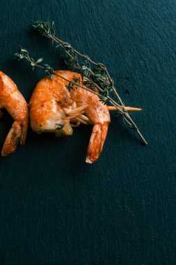 Sopa üzerinde kekik sprig ve gevrek kızarmış karides ile siyah kayrak yüzeyinin üst görünümü