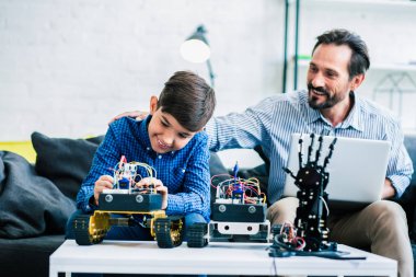 Pozitif yardımsever baba robotik mühendislik projesi üzerinde çalışan oğlunu öven