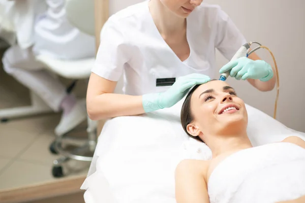 Professionele Cosmetoloog Zittend Buurt Van Cliënt Het Gebruik Van Handige — Stockfoto