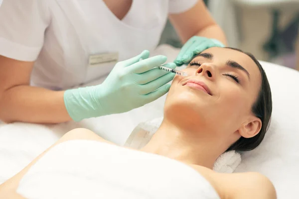 Calma Jovem Deitada Com Olhos Fechados Sorridente Enquanto Cosmetologista Profissional — Fotografia de Stock