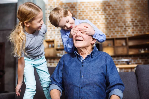 玩游戏 欢快的老人坐在沙发上 而他的小孙子闭上眼睛 — 图库照片