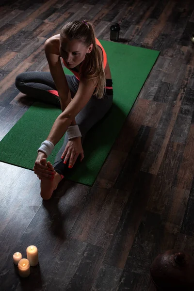 Mujer Deportiva Tranquila Sentada Esterilla Yoga Con Velas Frente Ella — Foto de Stock